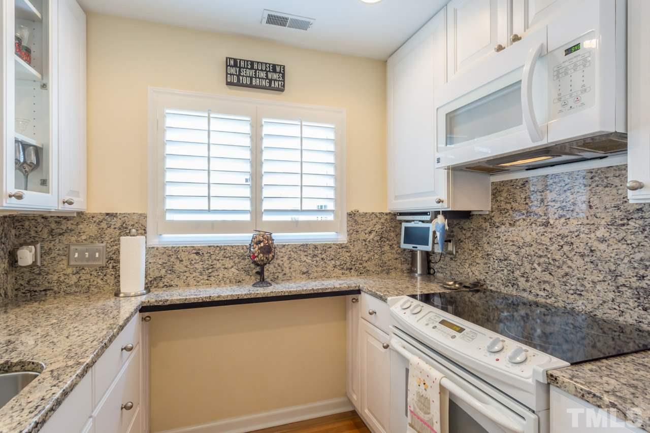1000 Brighthurst Drive, Unit 301 Raleigh, NC 27605 - Photo 5 of 24 a kitchen with granite countertop cabinets stainless steel appliances a sink and a window