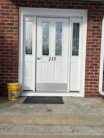 an empty room with wooden floor closet and windows