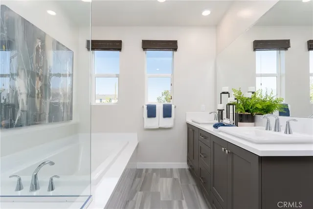 a bathroom with a tub sink and mirror