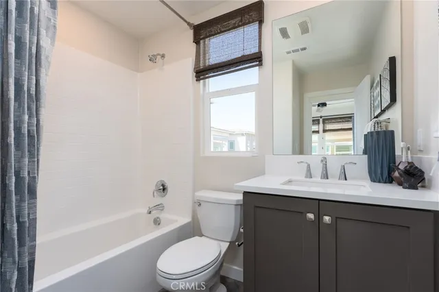 a bathroom with a bathtub shower sink vanity mirror and toilet