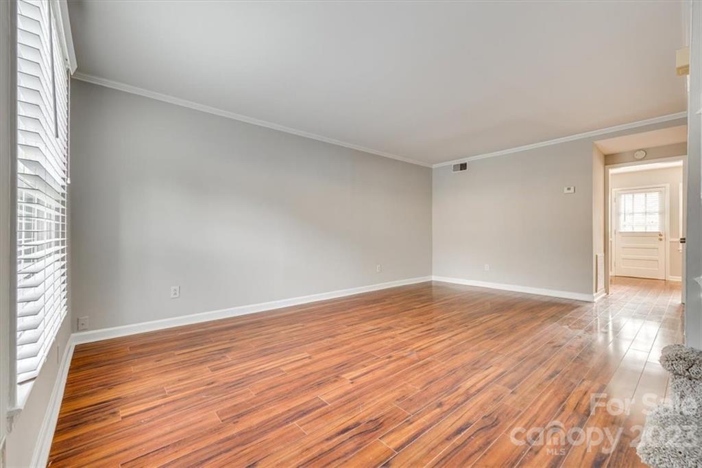 3722 Park Road, Unit I Charlotte, NC 28209 - Photo 4 of 27 a view of an empty room with wooden floor and a window
