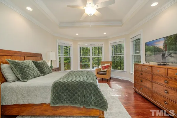a bedroom with a large bed and large windows