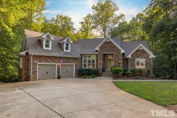 a front view of a house with yard and green space