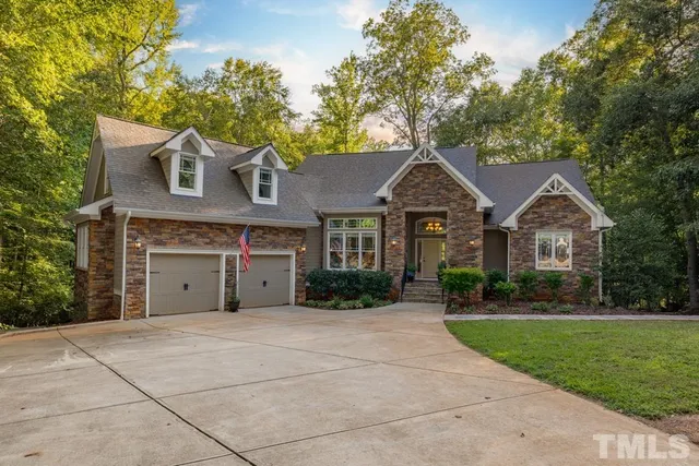 a front view of a house with yard and green space