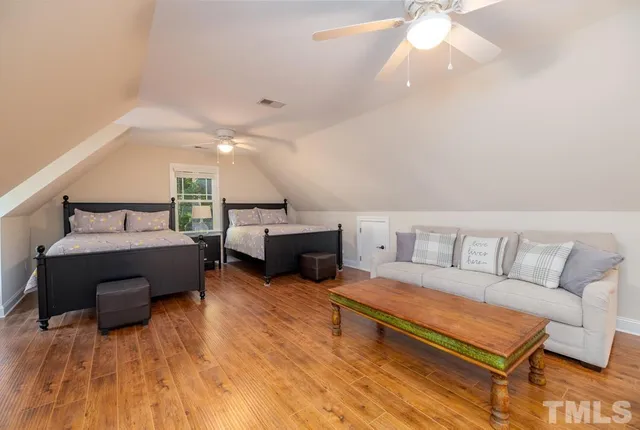 a view of a backyard with plants and large trees