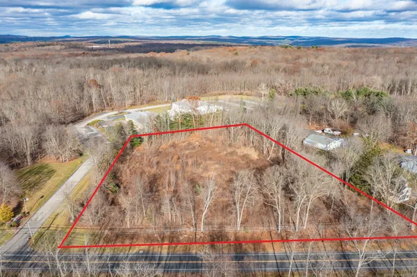 a view of a dry yard with wooden fence