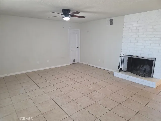 an empty room with windows and fireplace