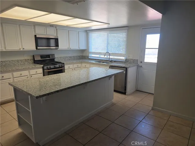 a kitchen with stainless steel appliances granite countertop a sink stove and microwave