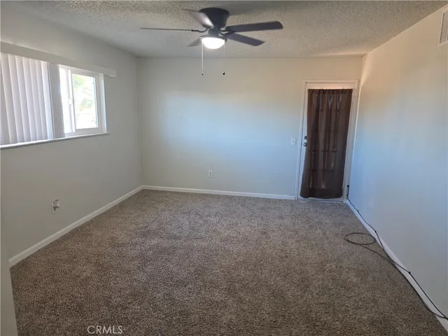 an empty room with windows and fan