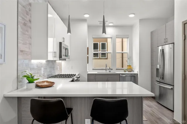 a kitchen with stainless steel appliances a sink a stove a refrigerator and cabinets