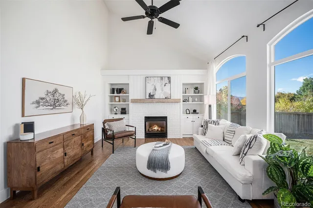 a living room with furniture a fireplace and a large window