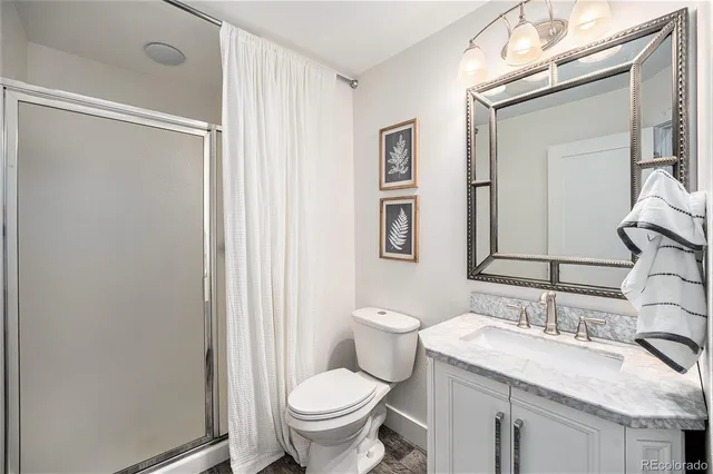 a bathroom with a granite countertop sink toilet and shower