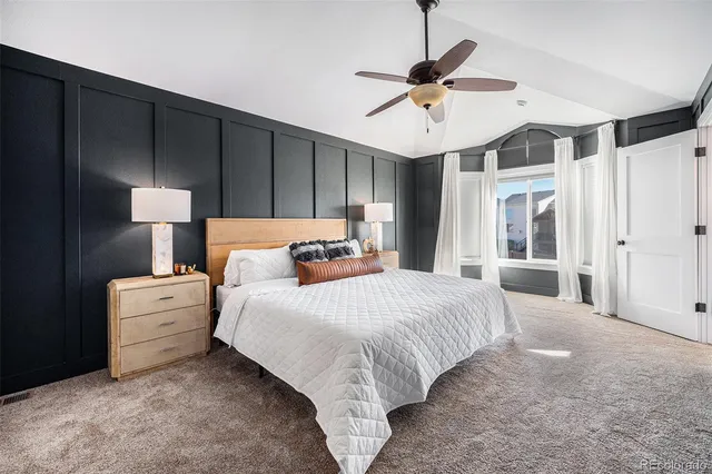 a spacious bedroom with a large bed and a ceiling fan