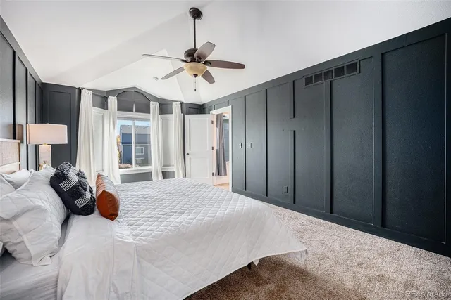 a bedroom with a large bed and a chandelier