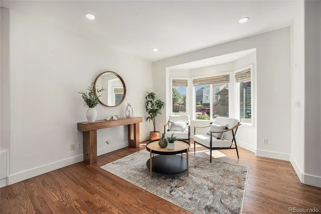 a living room with furniture a window and a potted plant