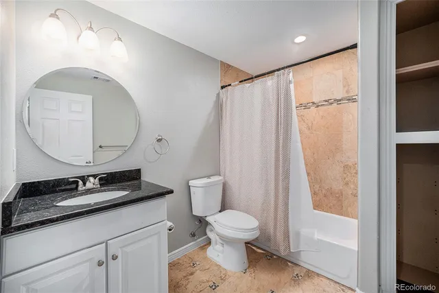 a bathroom with a granite countertop sink toilet and shower