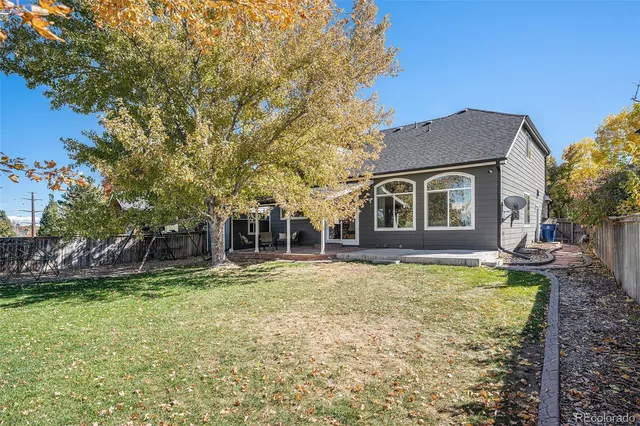 a backyard of a house with yard table and chairs