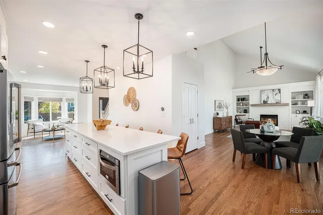 a large kitchen with kitchen island a lot of counter space a sink appliances and a dining table