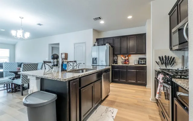 a kitchen with stainless steel appliances granite countertop a sink stove and refrigerator