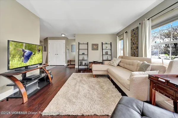 a living room with furniture flat screen tv and a large window