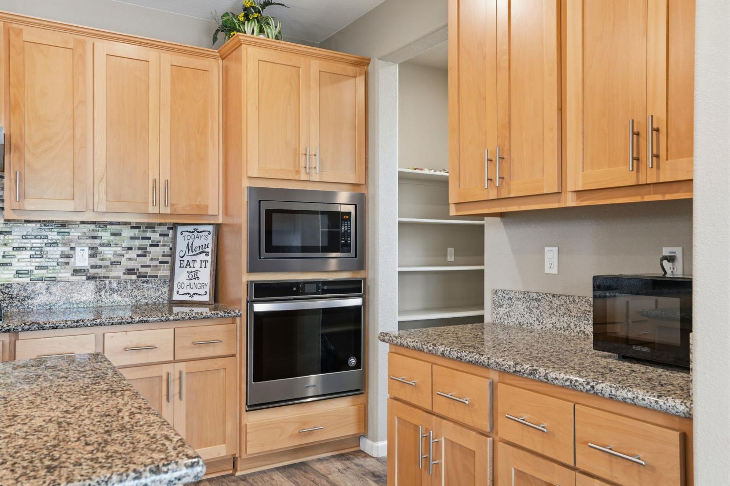 1816 Fire Power Avenue Manteca, CA 95337 - Photo 15 of 38 a kitchen with granite countertop a stove a sink and a microwave