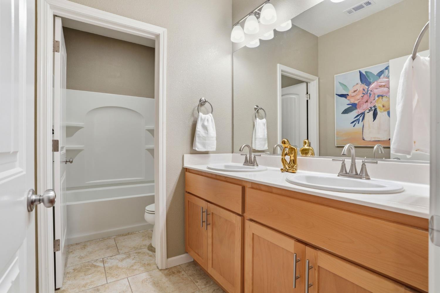 1816 Fire Power Avenue Manteca, CA 95337 - Photo 28 of 38 a bathroom with a granite countertop sink a mirror a vanity and shower