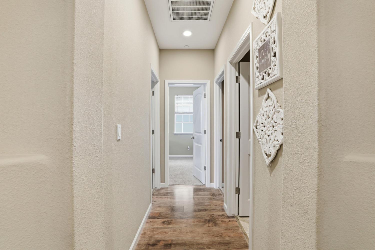 1816 Fire Power Avenue Manteca, CA 95337 - Photo 7 of 38 a view of a hallway with wooden floor and a bathroom