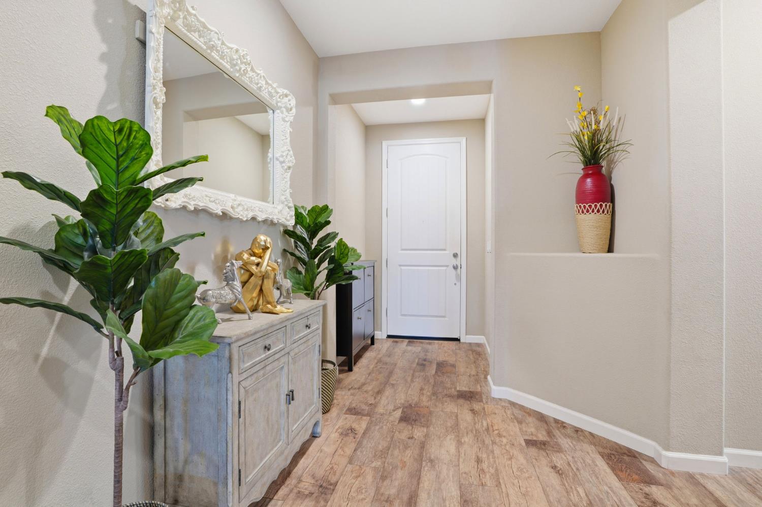 1816 Fire Power Avenue Manteca, CA 95337 - Photo 8 of 38 a view of a hallway with wooden floor and a potted plant