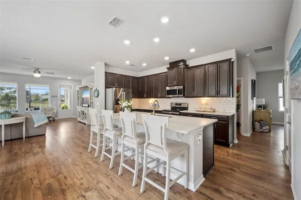 a kitchen with kitchen island granite countertop stainless steel appliances lots of counter top space a sink and cabinets