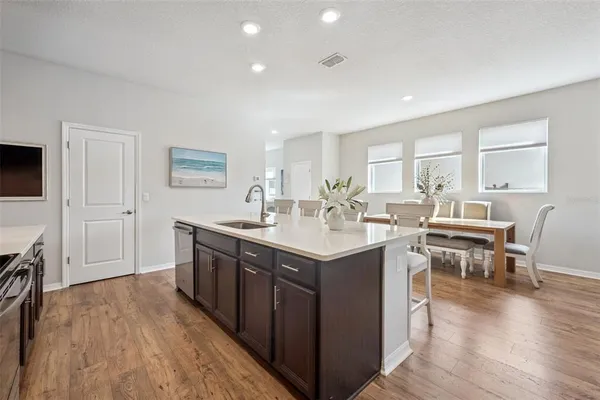 a kitchen with stainless steel appliances granite countertop a stove top oven a sink dishwasher and a refrigerator