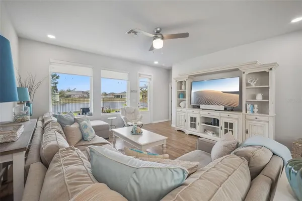 a living room with furniture flat screen tv and wooden floor