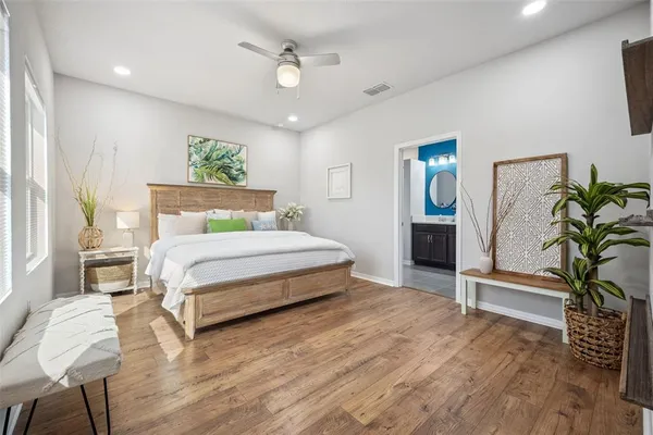 a bedroom with a bed chandelier and a window