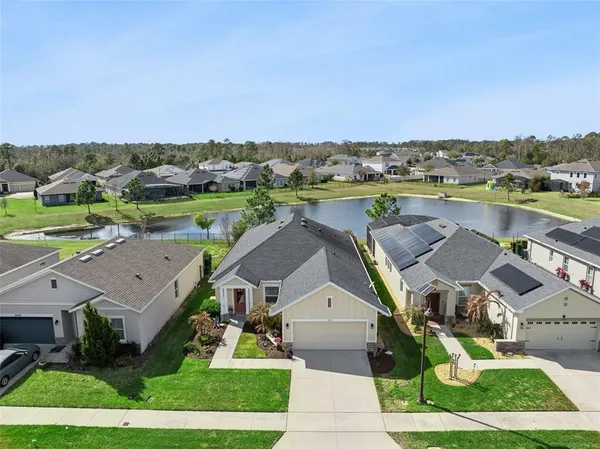 an aerial view of a house with a yard and lake view