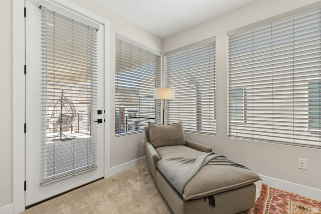 839 Walker Way St. George, UT 84770 - Photo 24 of 32 Room featuring a balcony access door, two large windows, neutral wall tones, and plush carpet flooring