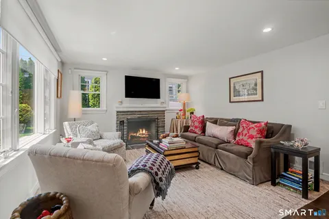 a living room with furniture a flat screen tv and a fireplace