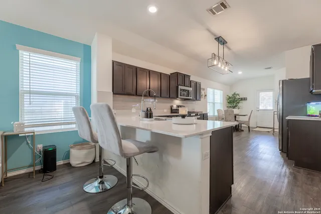 a kitchen with stainless steel appliances granite countertop a stove a sink dishwasher and a microwave oven with cabinets