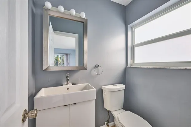 a view of a swimming pool with red chairs in front of a house