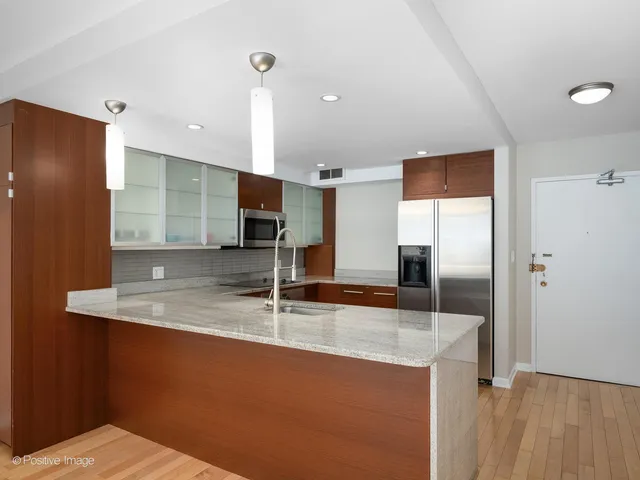 a kitchen with stainless steel appliances granite countertop a refrigerator and a sink