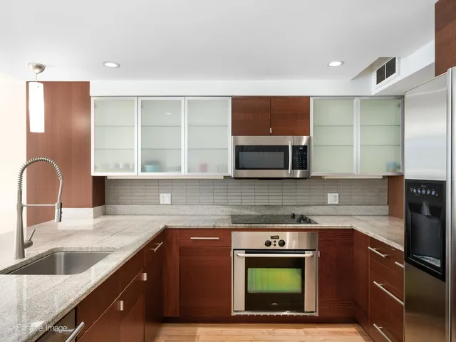 a kitchen with stainless steel appliances granite countertop a sink and a microwave