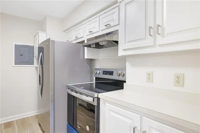 a kitchen with stainless steel appliances white cabinets and a refrigerator