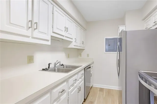 a kitchen with stainless steel appliances a sink a refrigerator and cabinets
