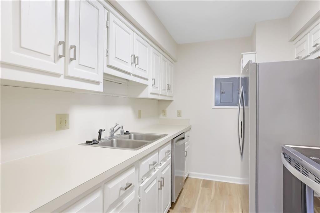 300 Johnson Ferry Road, Unit B103 Atlanta, GA 30328 - Photo 12 of 40 a kitchen with stainless steel appliances a sink a refrigerator and cabinets