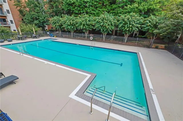 a view of a pool with a bench and trees