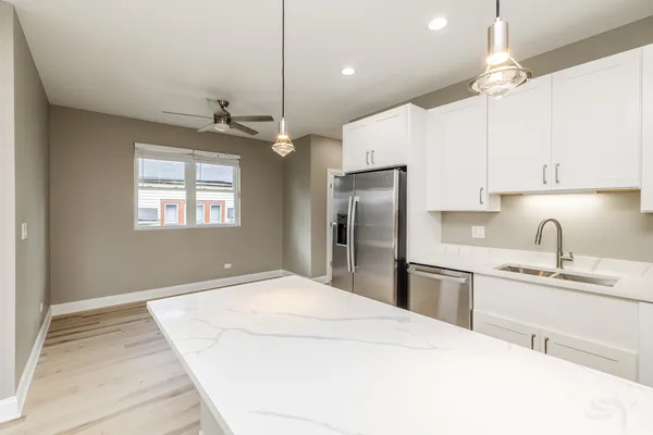 a kitchen with kitchen island a sink stainless steel appliances and window