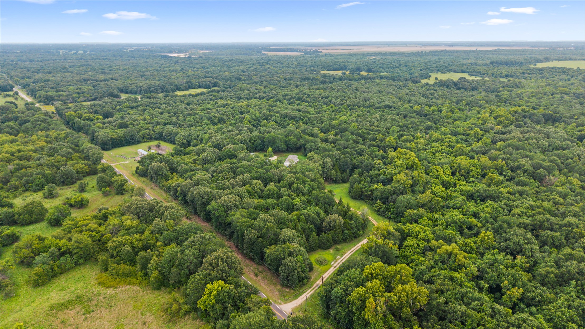1800 2110th Road Hugo, OK 74743 - Photo 25 of 27 Extensive wooded acreage with a central clearing featuring a primary residence and outbuildings