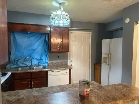 a kitchen with stainless steel appliances granite countertop wooden cabinets and chandelier