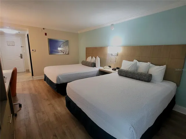 a bedroom with two beds and painting on the wall