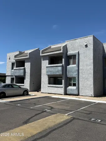 a view of building with car parked on road