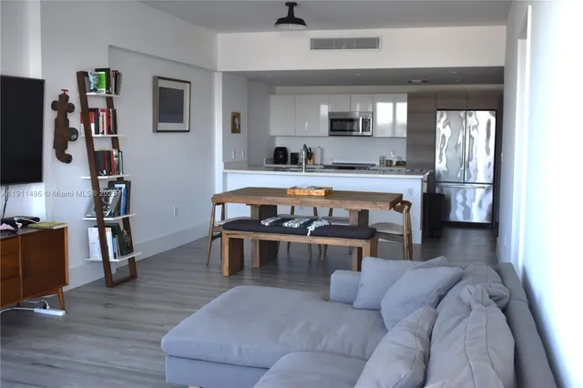 a living room with furniture a flat screen tv and kitchen view