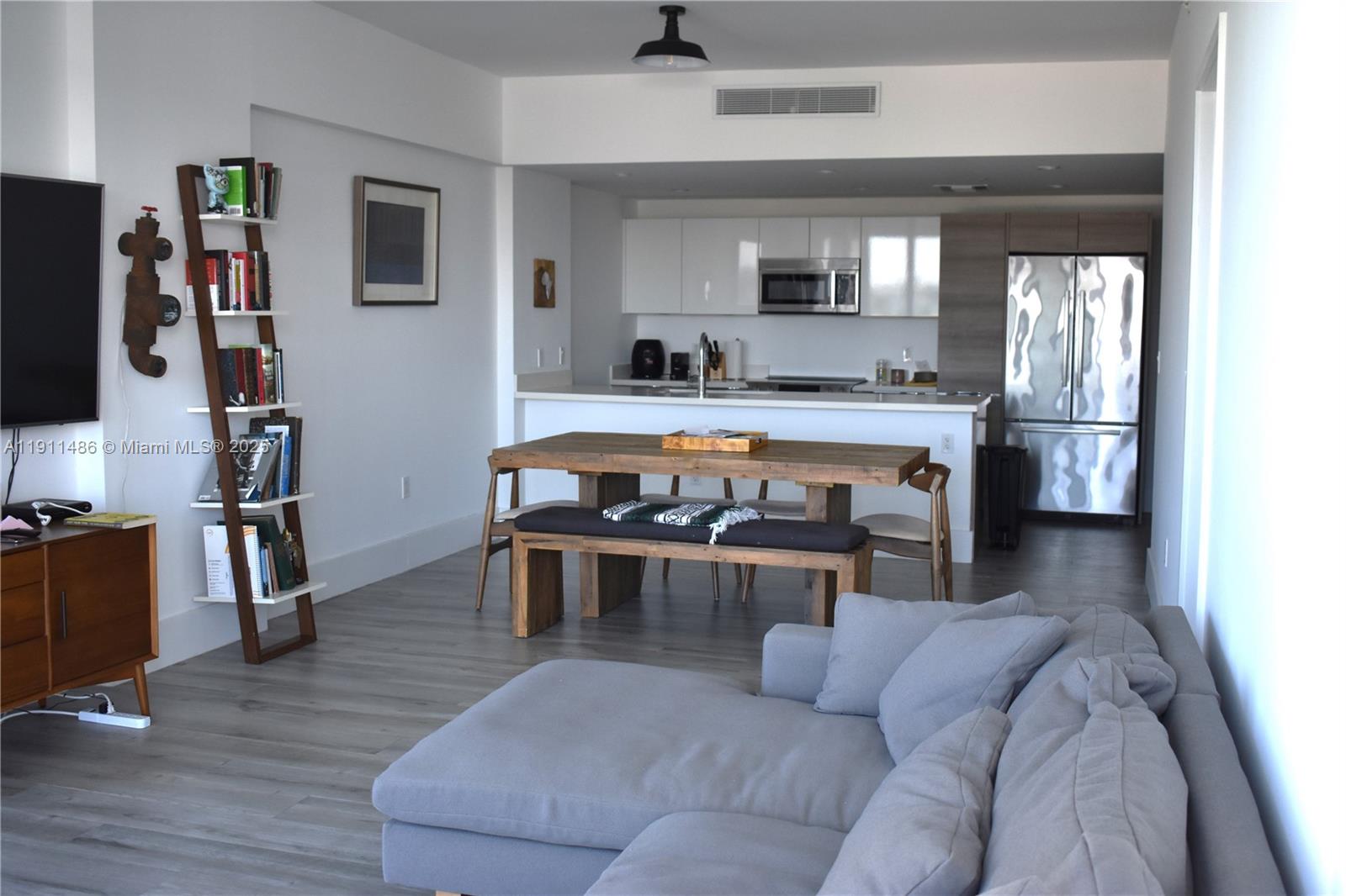 9940 West Bay Harbor Drive, Unit 6DN Bay Harbor Islands, FL 33154 - Photo 11 of 46 a living room with furniture a flat screen tv and kitchen view